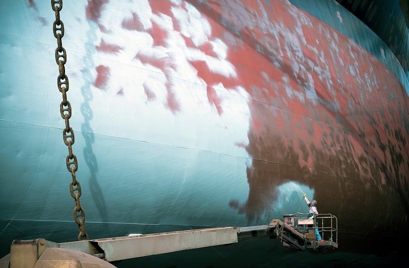 image showing ship hull being coated with antifouling paint