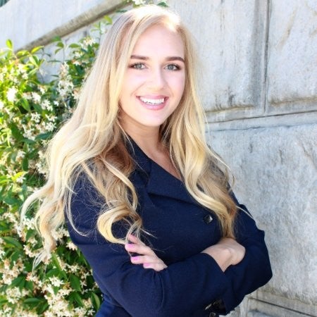 Anastasija Kuprijanova with her arms crossed smiling at the camera